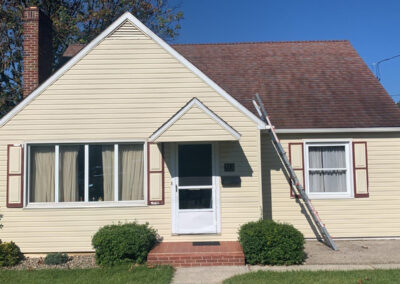 Yellow Siding on Brick House with ladder